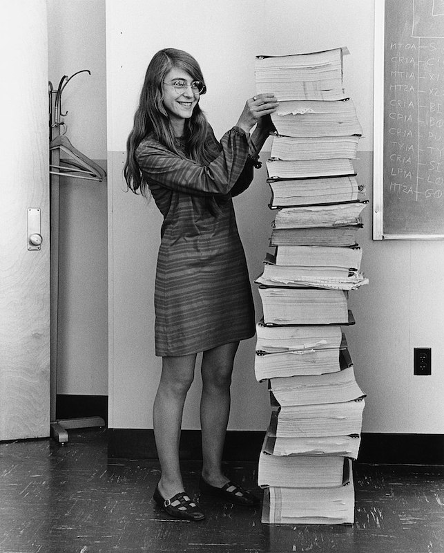 Director of Apollo Flight Computer Programming MIT Draper Laboratory, Margaret Hamilton, standing next to the program listings of the Apollo project that she and her team wrote.